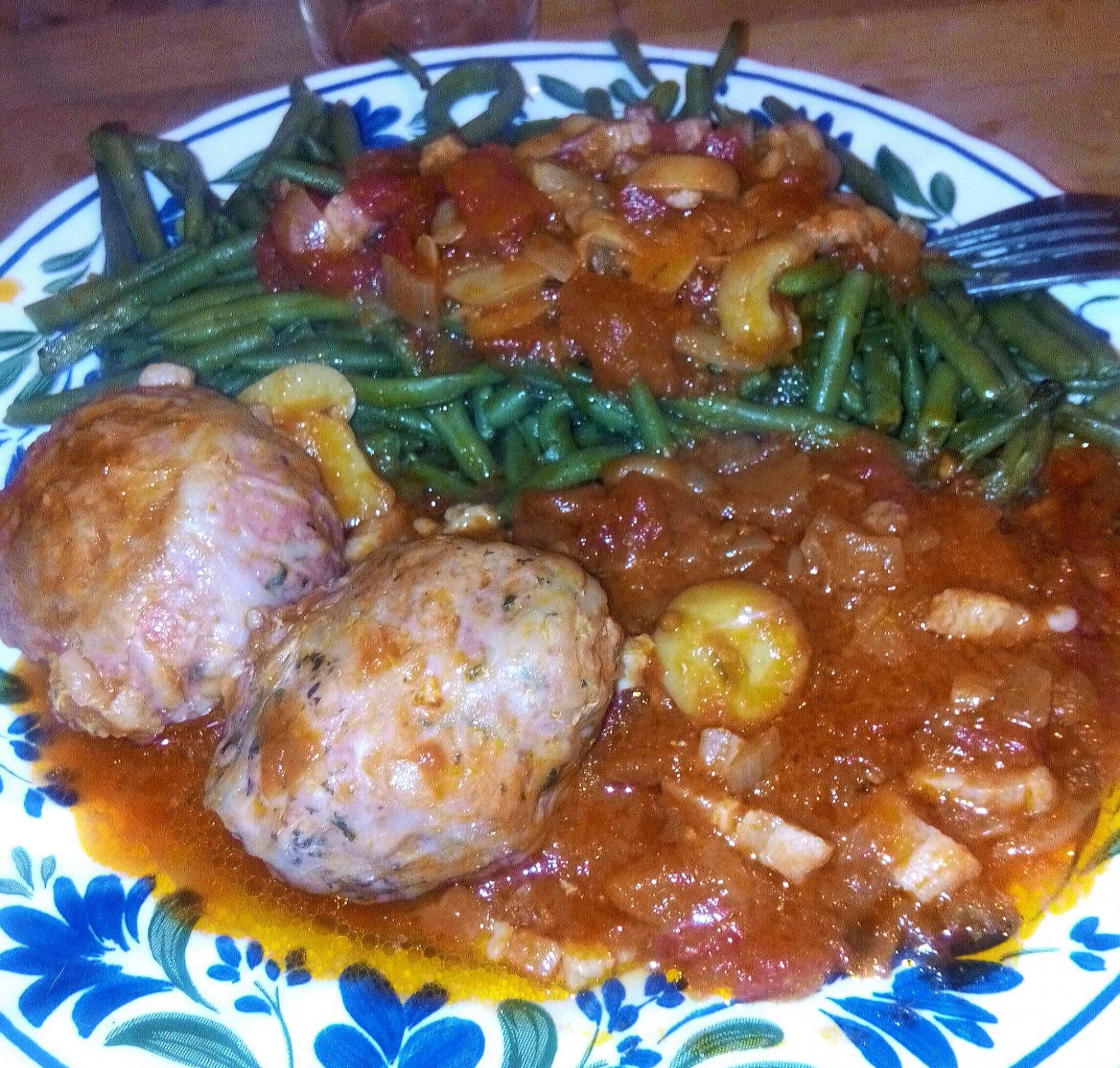 Flat sausage in a pork fat caul with tomatoes and mushrooms