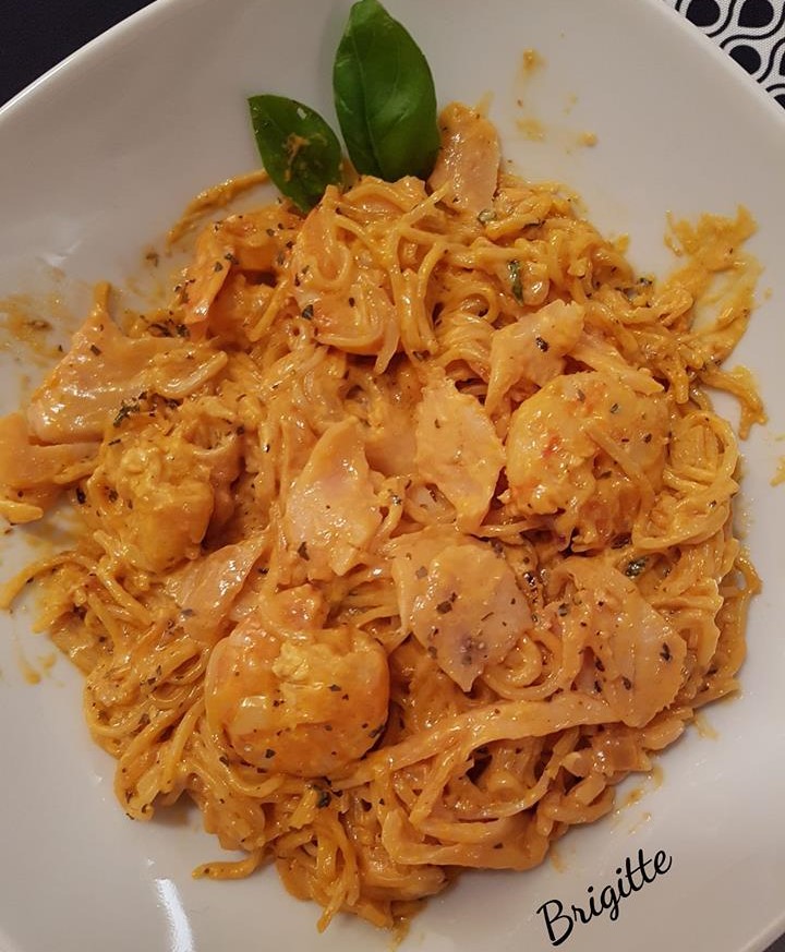 Noodles, shrimps, smoke salmon with a creamy tomato sauce and basil